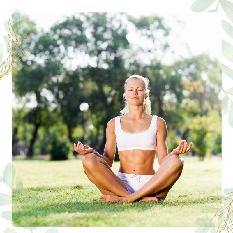 Woman meditating in lotus pose outdoors on grass