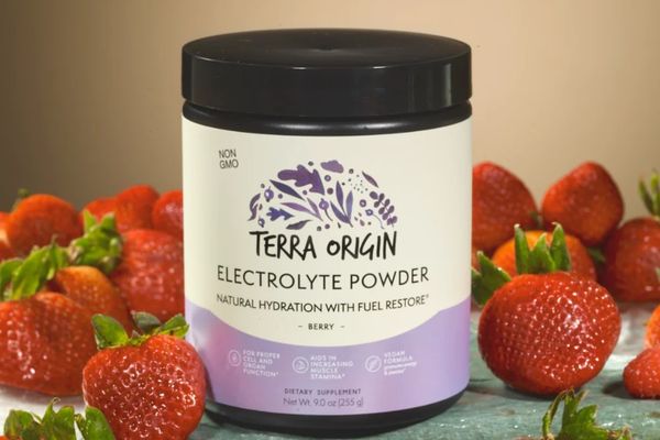 Terra Origin electrolyte powder container with strawberries on a wooden surface
