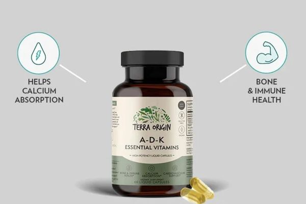 Terra Origin A-D-K essential vitamins bottle with labels on a gray background