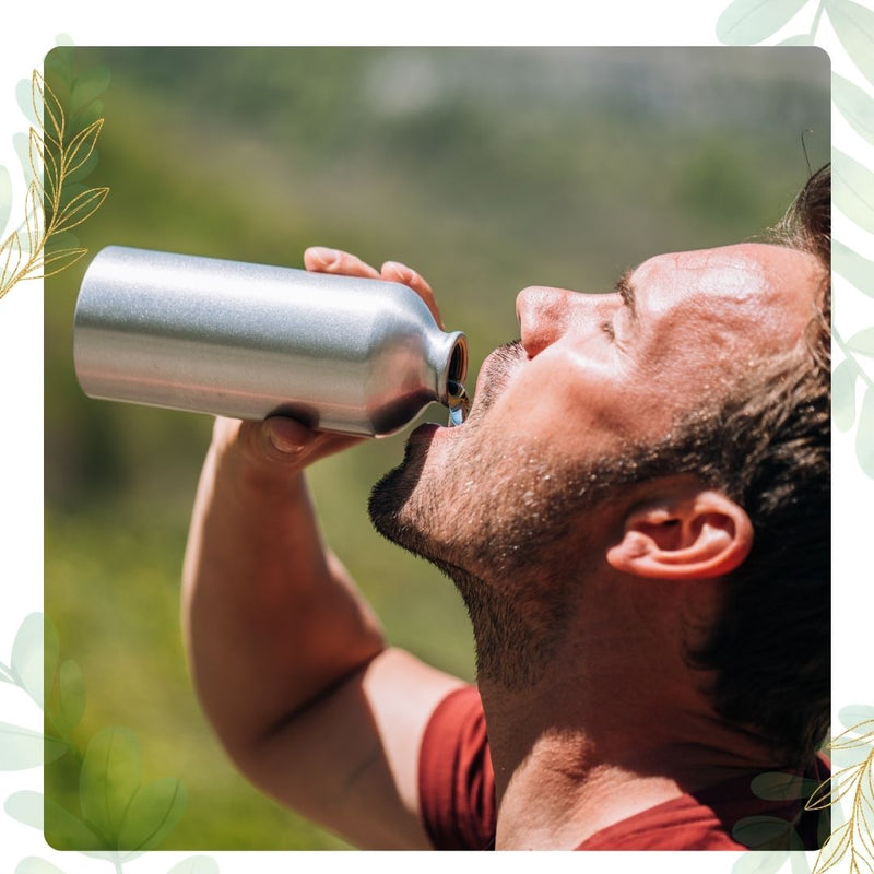 man drinking out of reusable container 