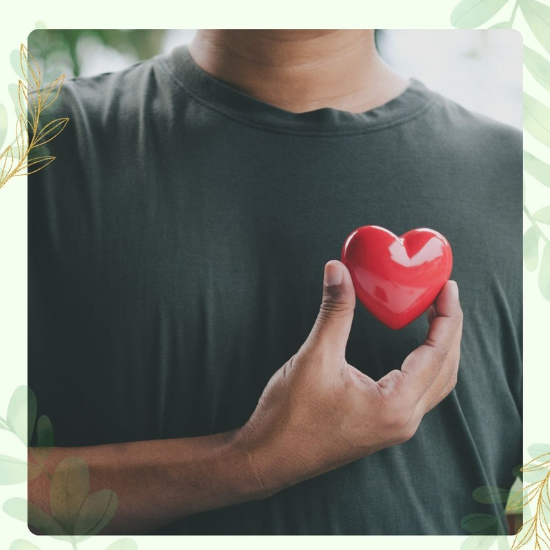 Person holding a red heart-shaped object against a blurred background