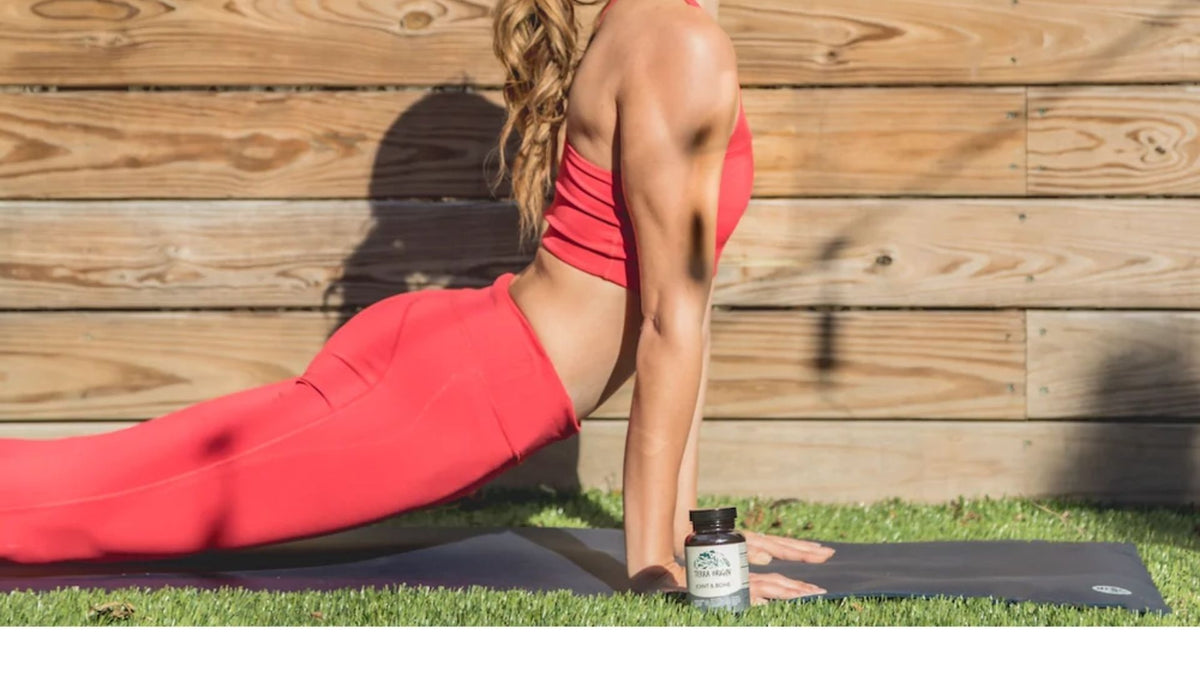 Woman in bright leggings doing an upward dog yoga pose on a mat