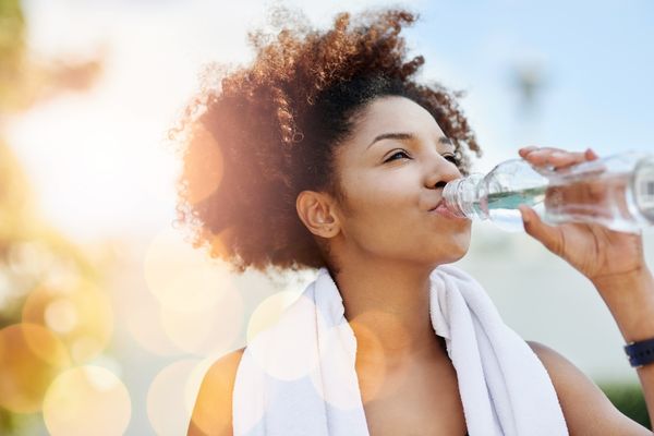 woman drinking out of water bottle 