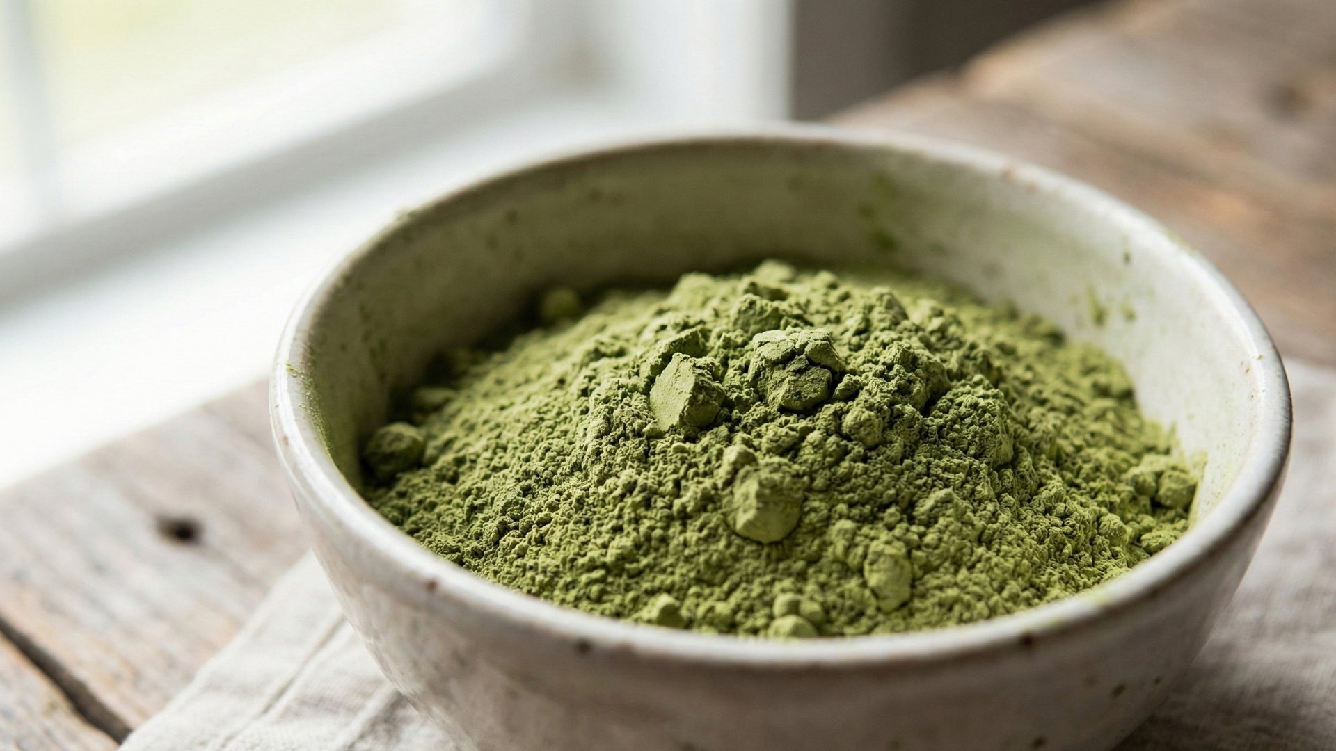 Bowl of green powder on a wooden surface