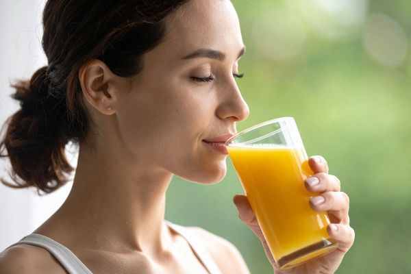 woman drinking supplement with juice